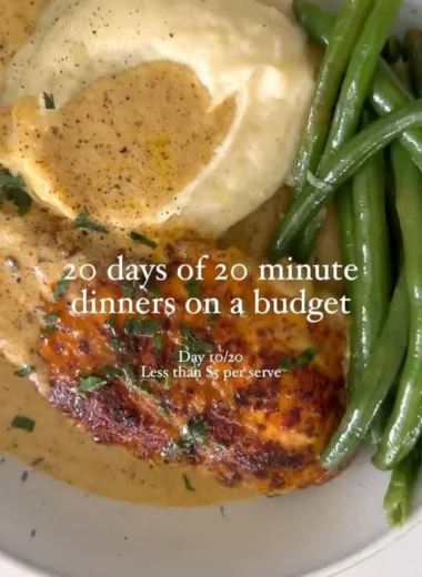 Creamy chicken schnitzel served with a side of vegetables and lemon wedges.
