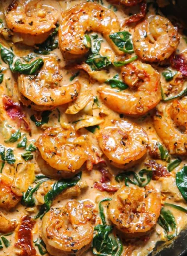 Delicious Tuscan shrimp with spinach, artichokes, and sun-dried tomatoes served on a plate