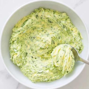 Basil pesto butter spread on bread with fresh basil leaves
