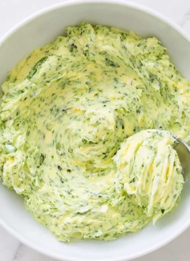 Basil pesto butter spread on bread with fresh basil leaves