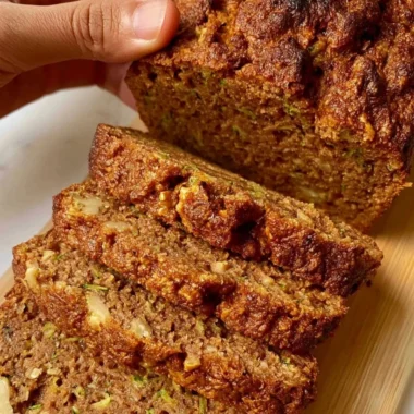 Delicious slice of best zucchini bread on a wooden table.