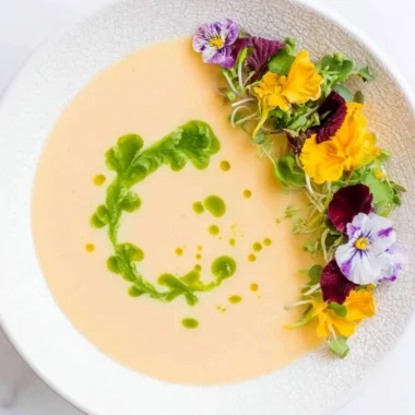 Chilled peach soup served in a bowl with fresh peach slices and mint garnish.