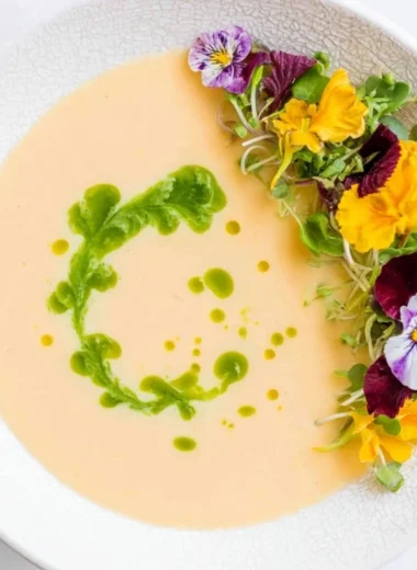 Chilled peach soup served in a bowl with fresh peach slices and mint garnish.