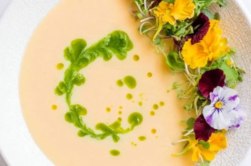 Chilled peach soup served in a bowl with fresh peach slices and mint garnish.