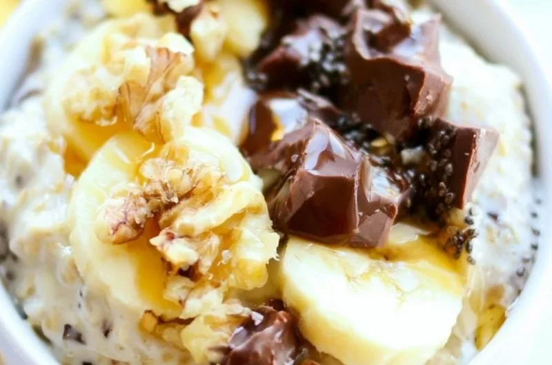 Bowl of Chunky Monkey Overnight Oats topped with banana slices and chocolate chips