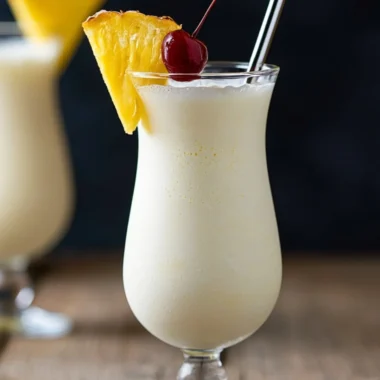 Classic Piña Colada cocktail garnished with pineapple and cherry