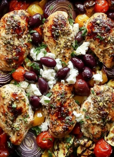 Sheet pan meal featuring Greek chicken and colorful veggies roasted to perfection.