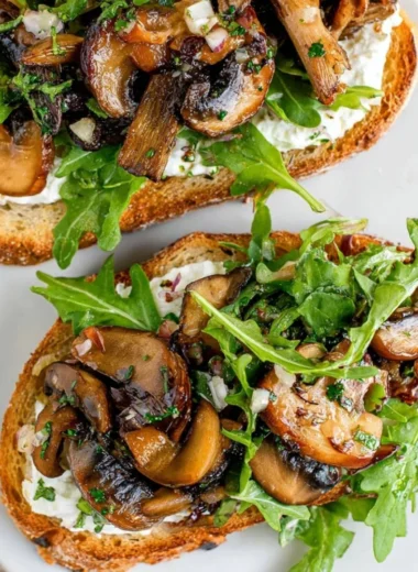 Creamy mushroom toast topped with fresh herbs on a rustic bread slice.