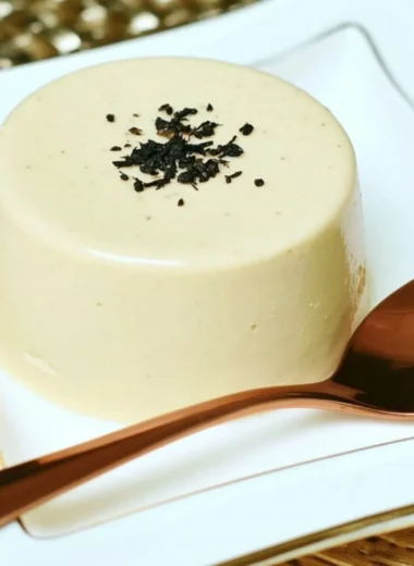 Earl Grey Panna Cotta dessert topped with tea leaves and lemon zest