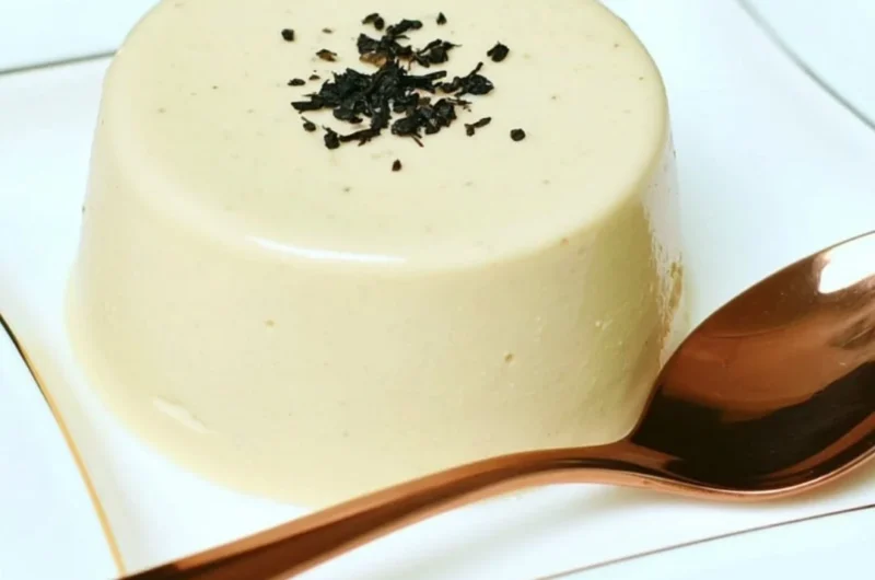 Earl Grey Panna Cotta dessert topped with tea leaves and lemon zest
