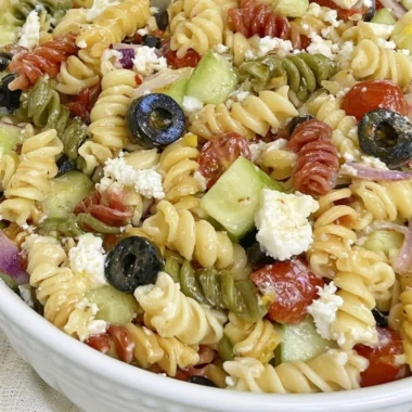 Bowl of easy Italian Pasta Salad with colorful vegetables and dressing