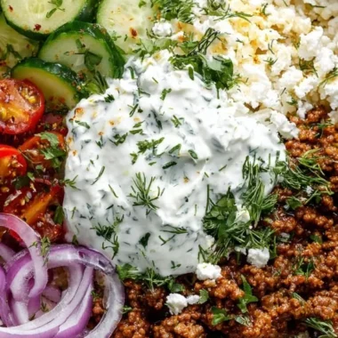 Healthy Greek Ground Beef Bowl topped with Tzatziki sauce and fresh veggies