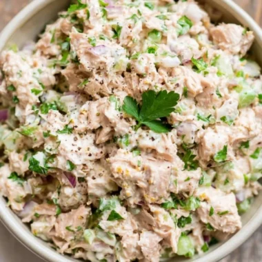 A healthy bowl of tuna salad with fresh vegetables and dressing