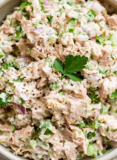 A healthy bowl of tuna salad with fresh vegetables and dressing
