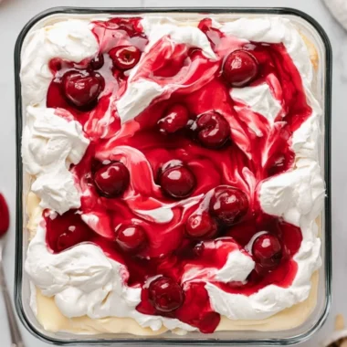 Slices of Heaven on Earth Cake with creamy layers and garnished with berries.