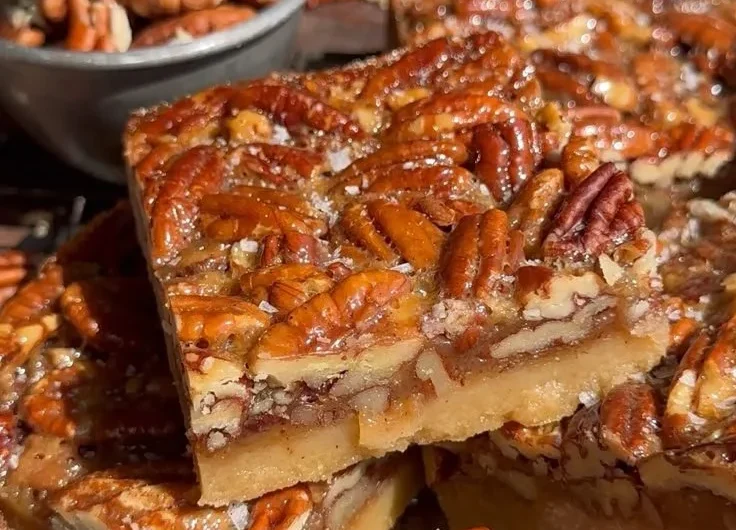 Delicious pecan pie bars topped with nuts and caramel sauce