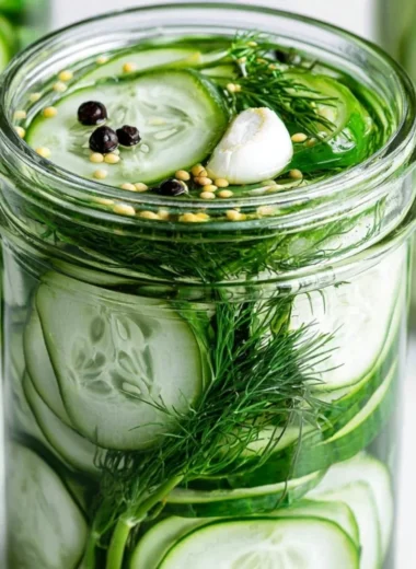 Homemade super easy refrigerator dill pickles in a glass jar on a wooden table