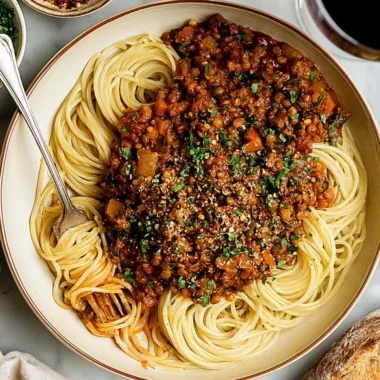 Delicious vegan lentil bolognese served with pasta and fresh herbs