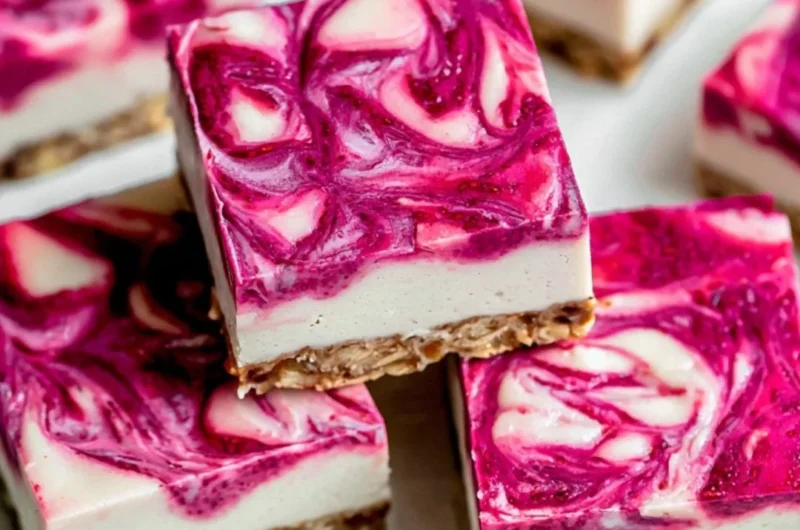 Delicious Vegan Raspberry Cheesecake Bars topped with fresh raspberries.