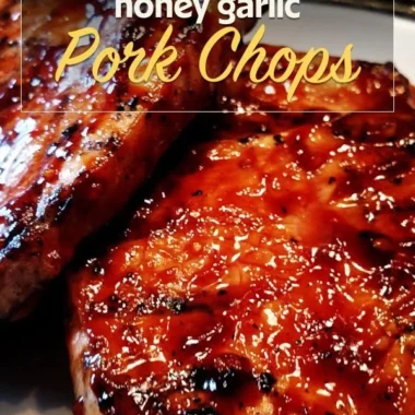 Delicious honey garlic pork chops served on a plate with fresh herbs.