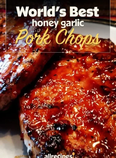 Delicious honey garlic pork chops served on a plate with fresh herbs.