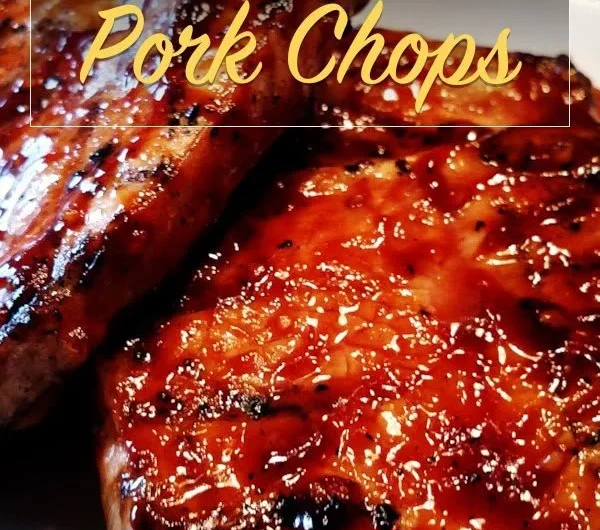 Delicious honey garlic pork chops served on a plate with fresh herbs.