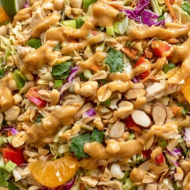 A vibrant bowl of cozy Thai chicken salad with fresh vegetables and chicken.