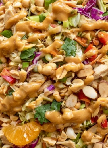 A vibrant bowl of cozy Thai chicken salad with fresh vegetables and chicken.