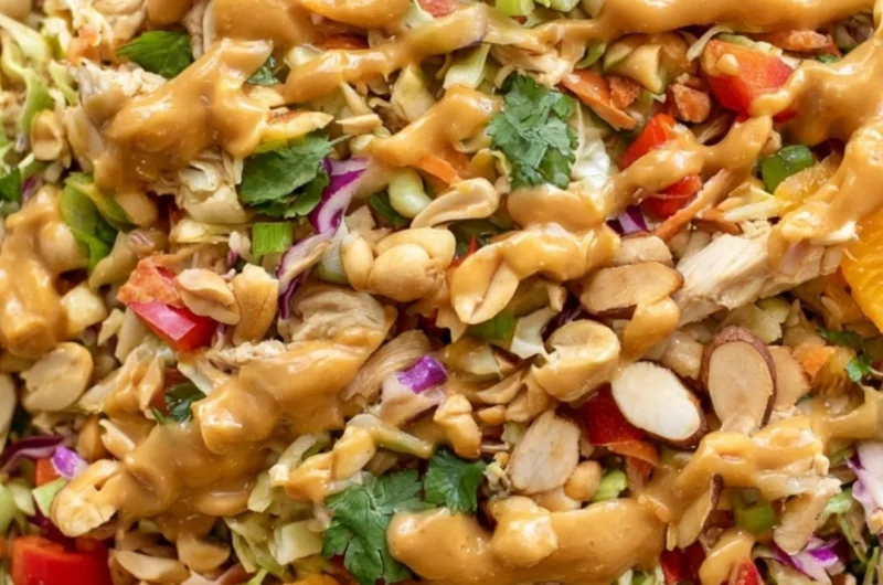 A vibrant bowl of cozy Thai chicken salad with fresh vegetables and chicken.