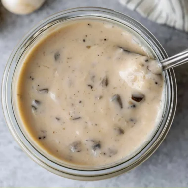 Bowl of creamy mushroom soup garnished with herbs