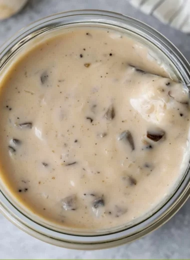 Bowl of creamy mushroom soup garnished with herbs