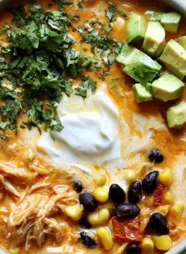 Bowl of creamy chicken enchilada soup topped with cilantro and cheese
