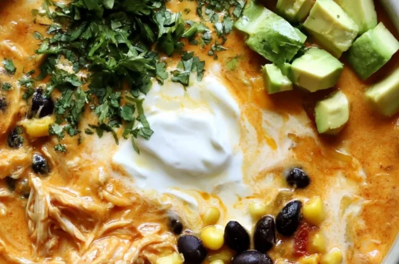 Bowl of creamy chicken enchilada soup topped with cilantro and cheese