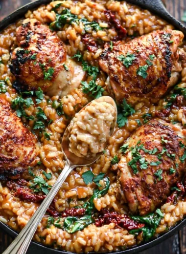 Creamy sun-dried tomato and spinach risotto with chicken thighs in a bowl