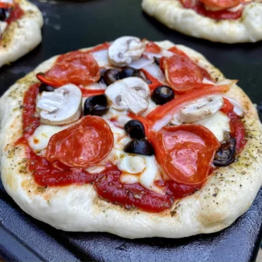 Homemade pizza cooked on a Blackstone griddle with fresh toppings.