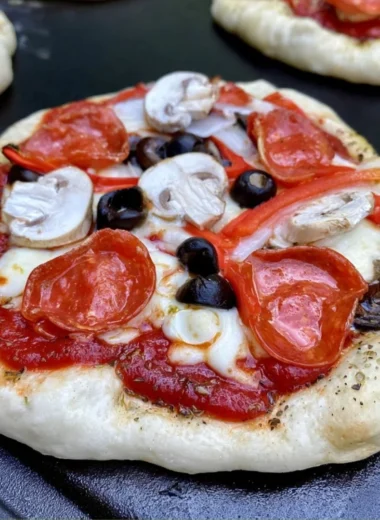 Homemade pizza cooked on a Blackstone griddle with fresh toppings.