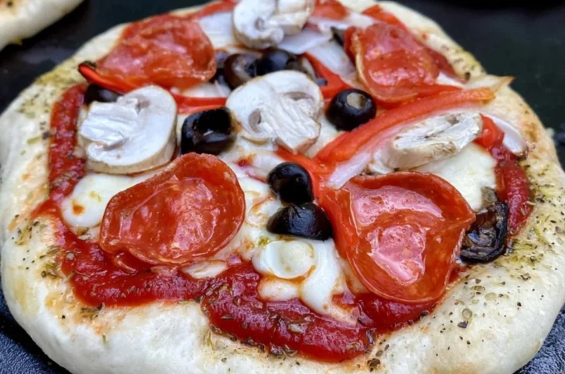 Homemade pizza cooked on a Blackstone griddle with fresh toppings.