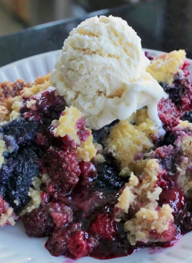 Easy blackberry dump cake topped with fresh berries and whipped cream