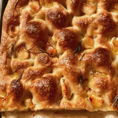 Freshly baked easy sourdough focaccia topped with herbs and olive oil