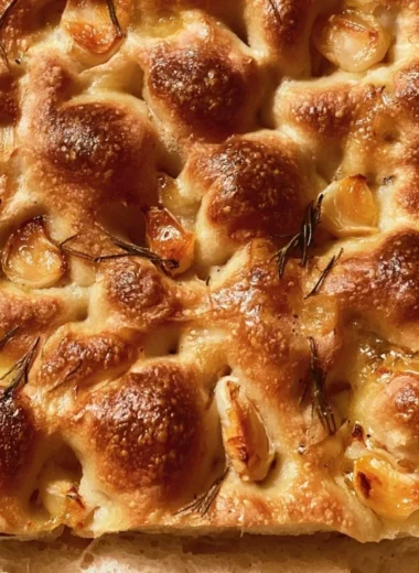 Freshly baked easy sourdough focaccia topped with herbs and olive oil
