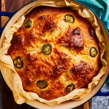 Loaf of jalapeno cheddar Dutch oven bread with a golden crust.