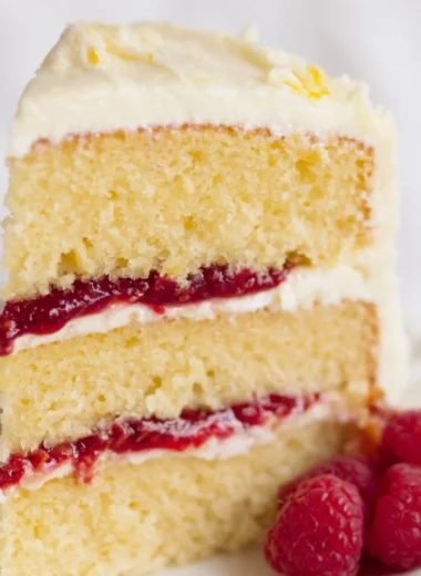 Delicious Raspberry Lemon Cake topped with fresh raspberries and lemon zest.