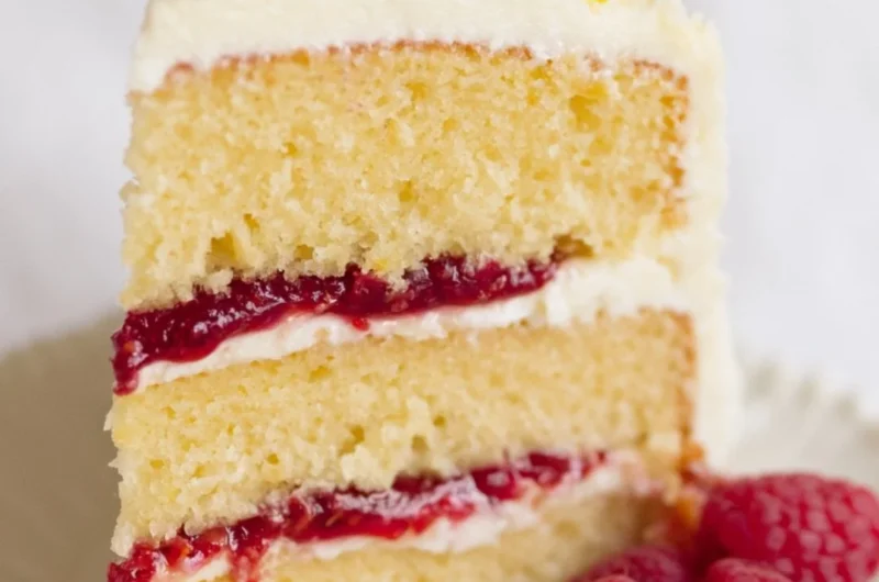 Delicious Raspberry Lemon Cake topped with fresh raspberries and lemon zest.