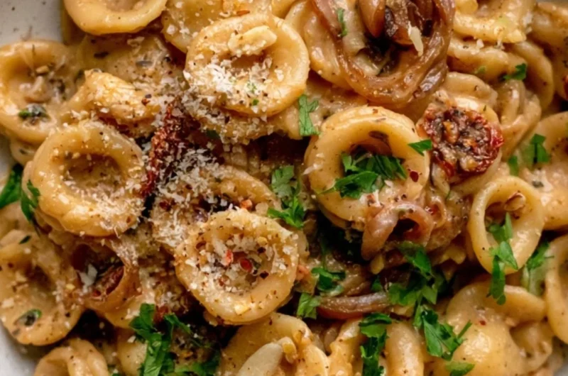 Cozy caramelized onion pasta served in a bowl with herbs and cheese garnish