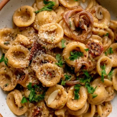 Cozy caramelized onion pasta served in a bowl with herbs and cheese.