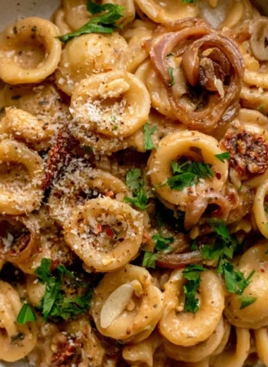 Cozy caramelized onion pasta served in a bowl with herbs and cheese.