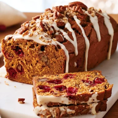 Slice of homemade Pumpkin Cranberry Quick Bread on a wooden table