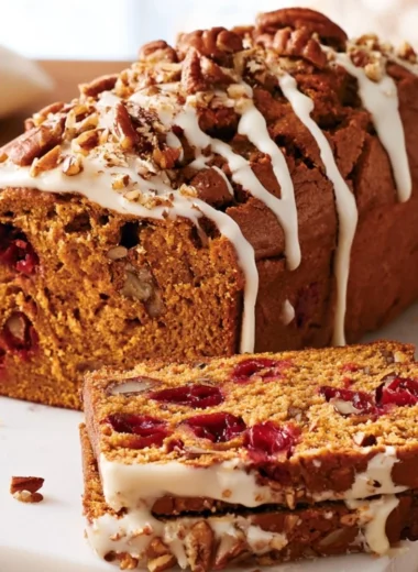 Slice of homemade Pumpkin Cranberry Quick Bread on a wooden table